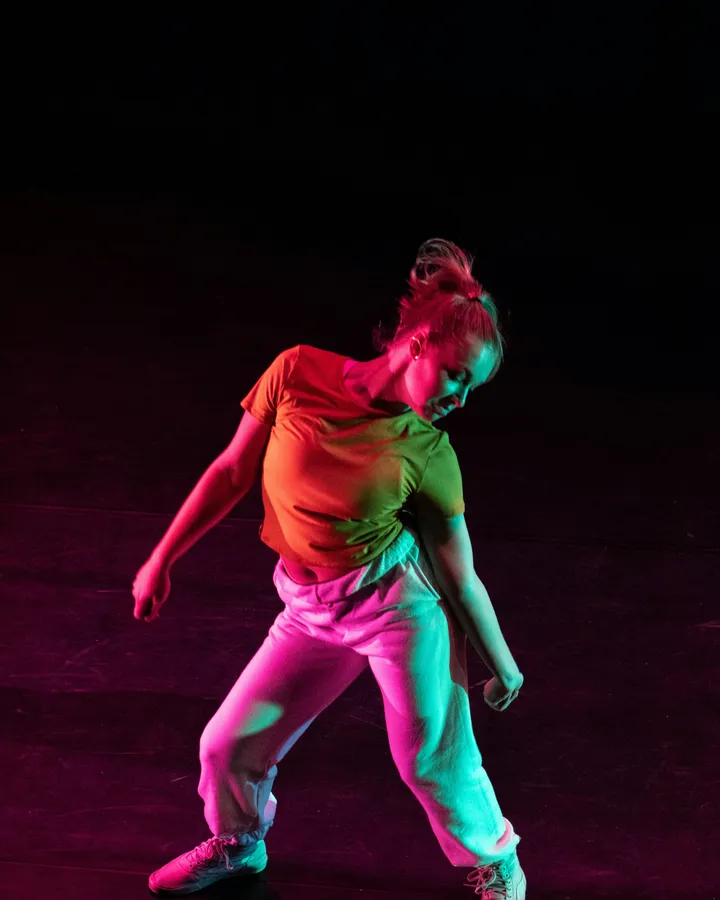 Tancerka Dyemotion w dynamicznym ruchu, oświetlona kolorowym reflektorem